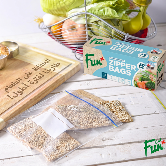 Fun brand zipper bags shown in use with food items like sesame seeds and vegetables, alongside the product packaging box on a light wooden table.
